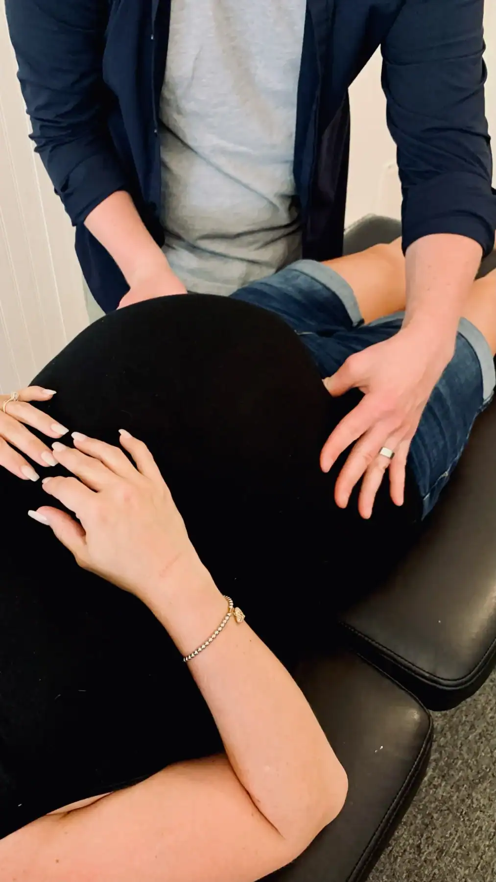 Photo of a chiropractor feeling his pregnant patient's belly