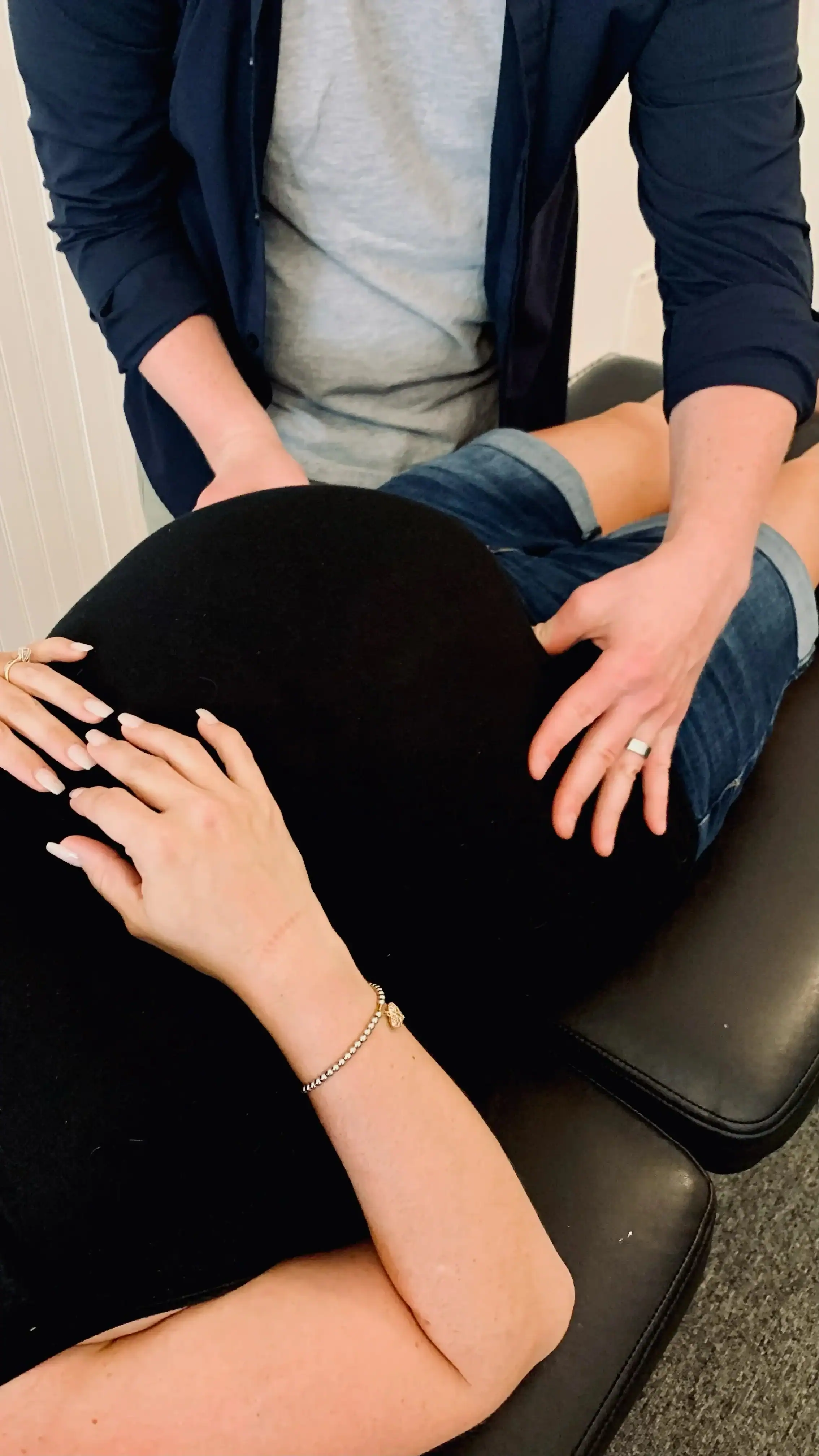 Photo of a chiropractor feeling his pregnant patient's belly