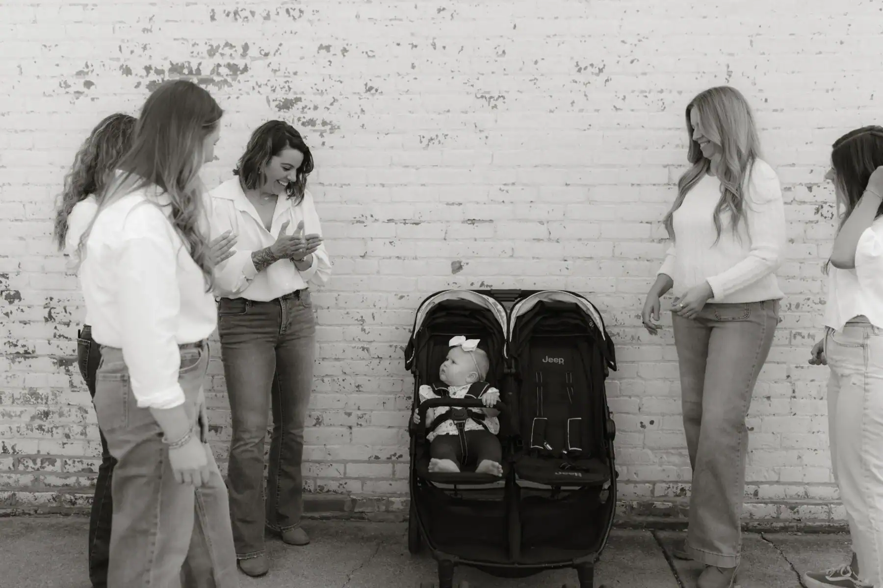 Photo of the Adjusted Living team standing around a stroller smiling at a baby