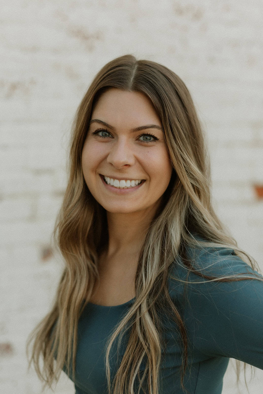 Photo of Jensen Berke, a woman, posing in front of a wood panel wall