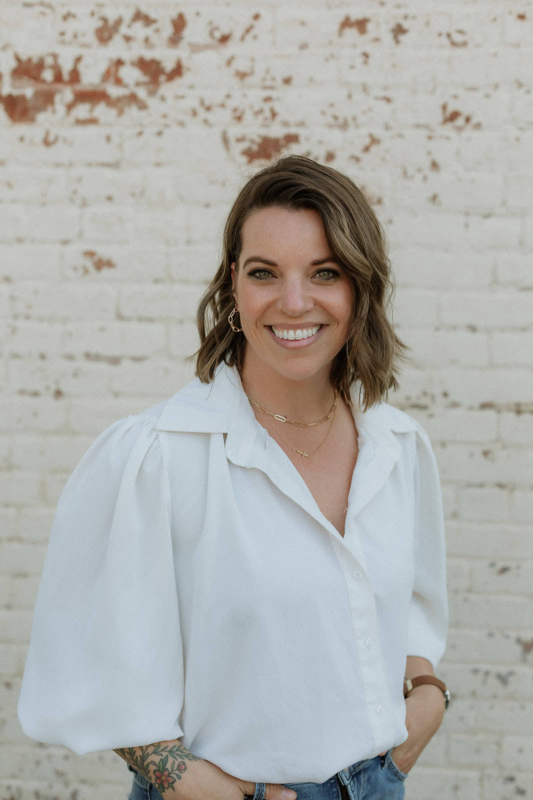 Photo of Katie McVicker, a woman, posing in front of a wood panel wall