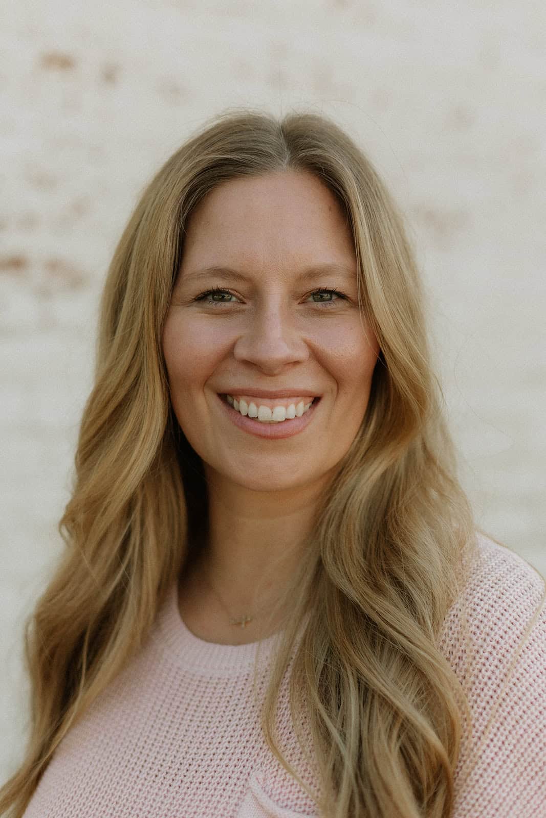 Photo of Lacey Peach, a woman, posing in front of a wood panel wall