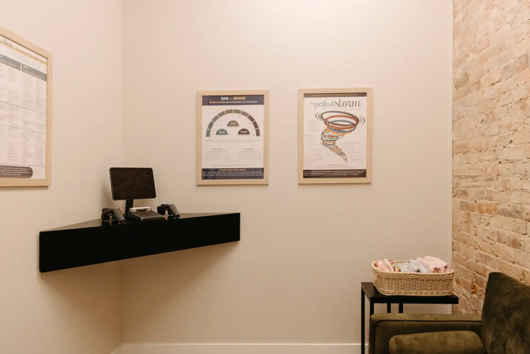 Photo of a chiropractic office with a monitor on a floating desk next to hanged posters describing autism and chiropractic care