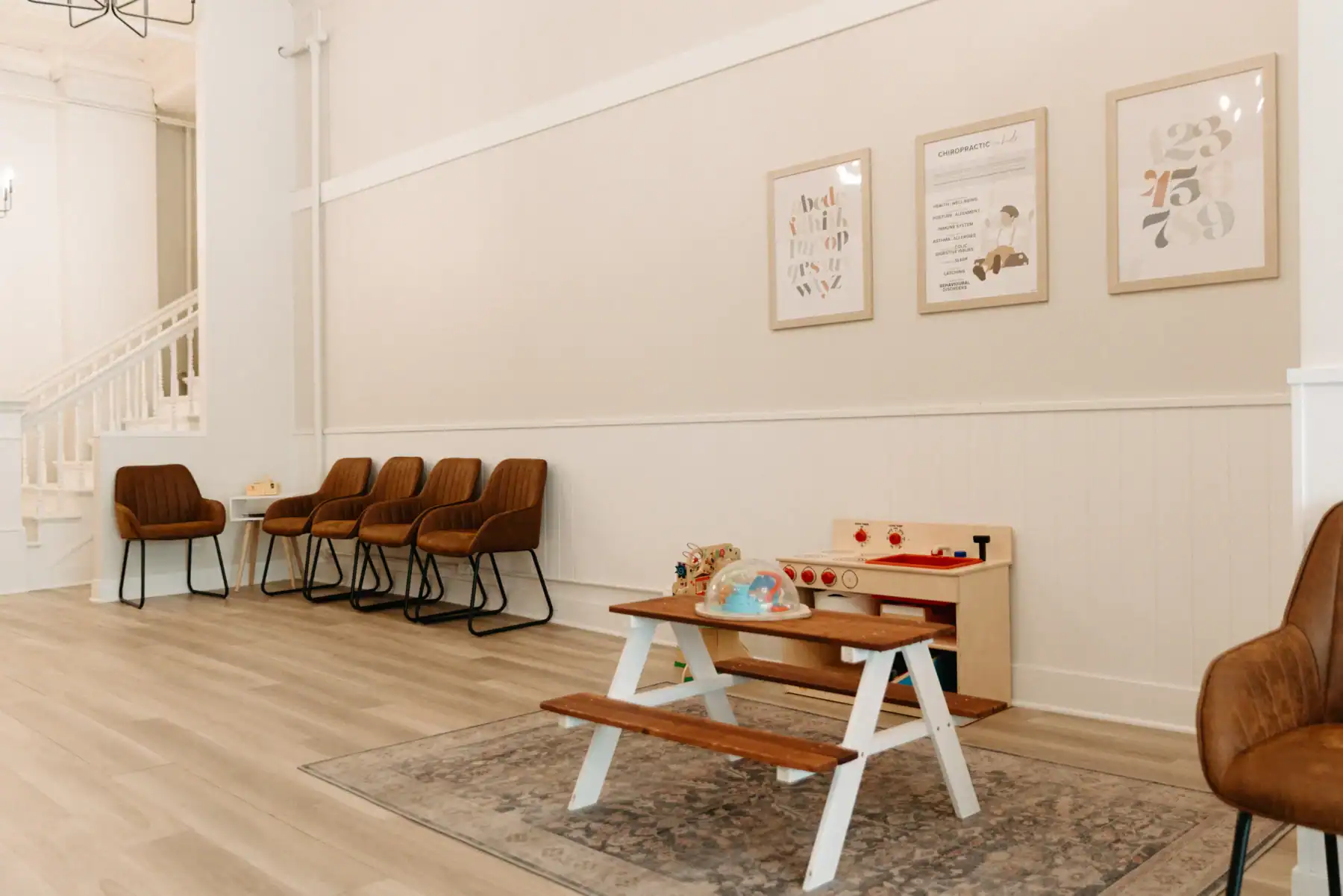 photo of a waiting room with chairs next to a kids play area with a play oven and picnic table
