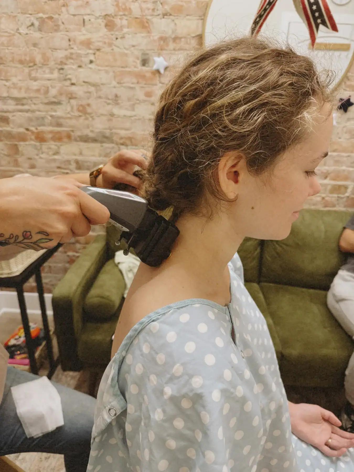 photo of a girl sitting in a patient robe while getting the back of her neck scanned by a chiropractor