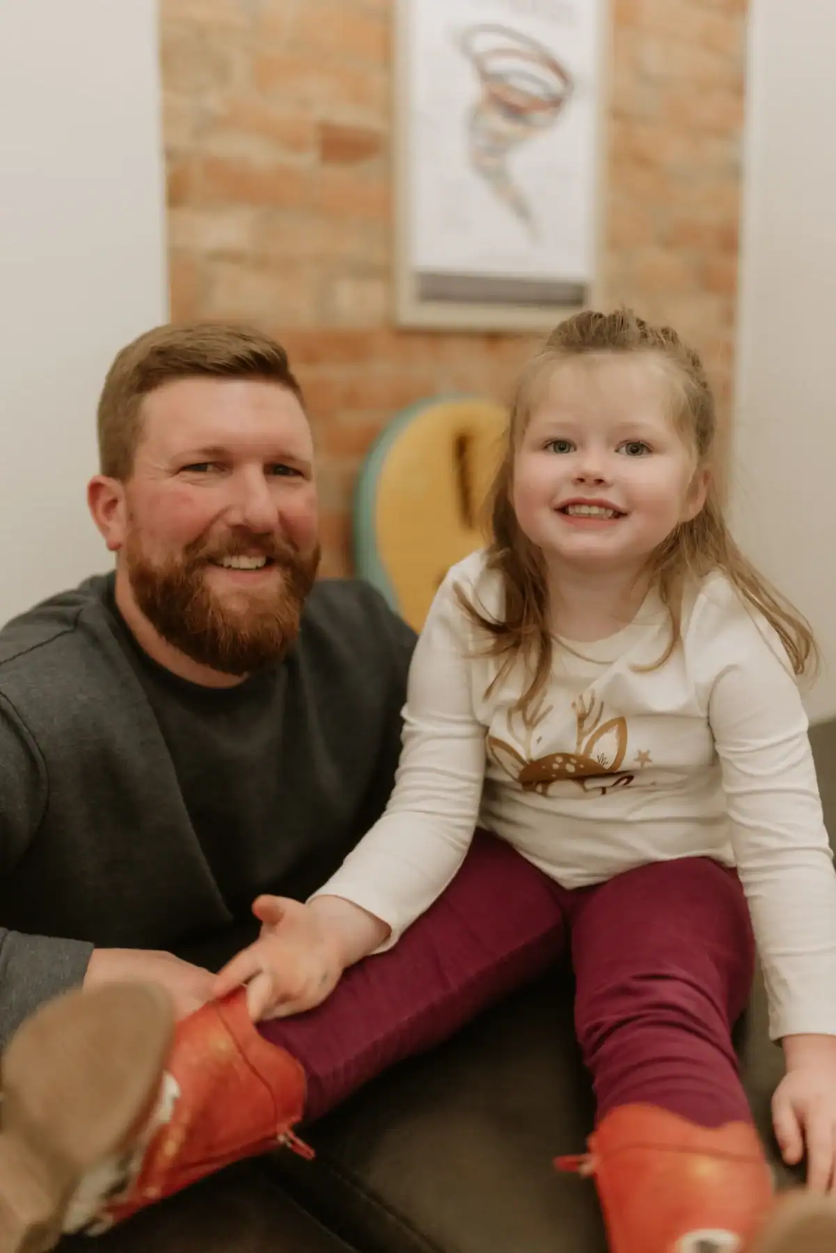 photo of Dr. Ryan at Adjusted Living smiling next to a young girl sitting on a black bench