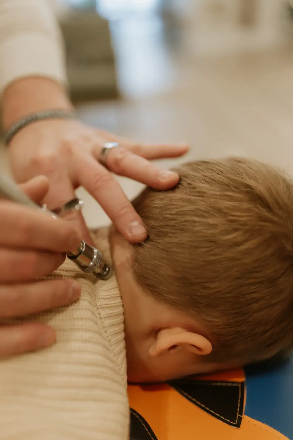 photo of a chiropractor adjusting a child's neck as he lies face down on a bench