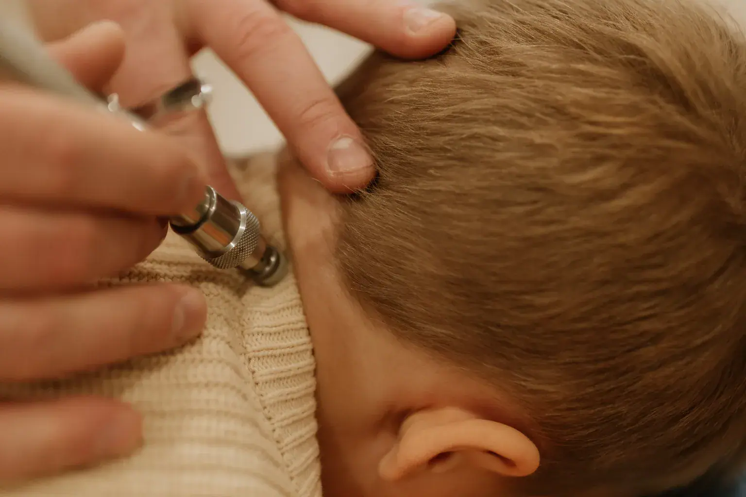 photo of a chiropractor using a scanning tool near a boy s neck to check nervous system function